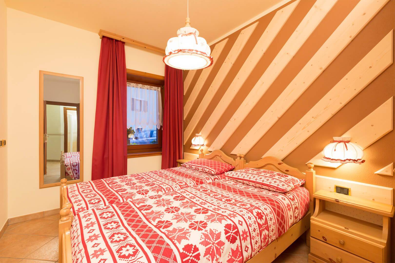 Holzwand und Doppelbett in Livigno