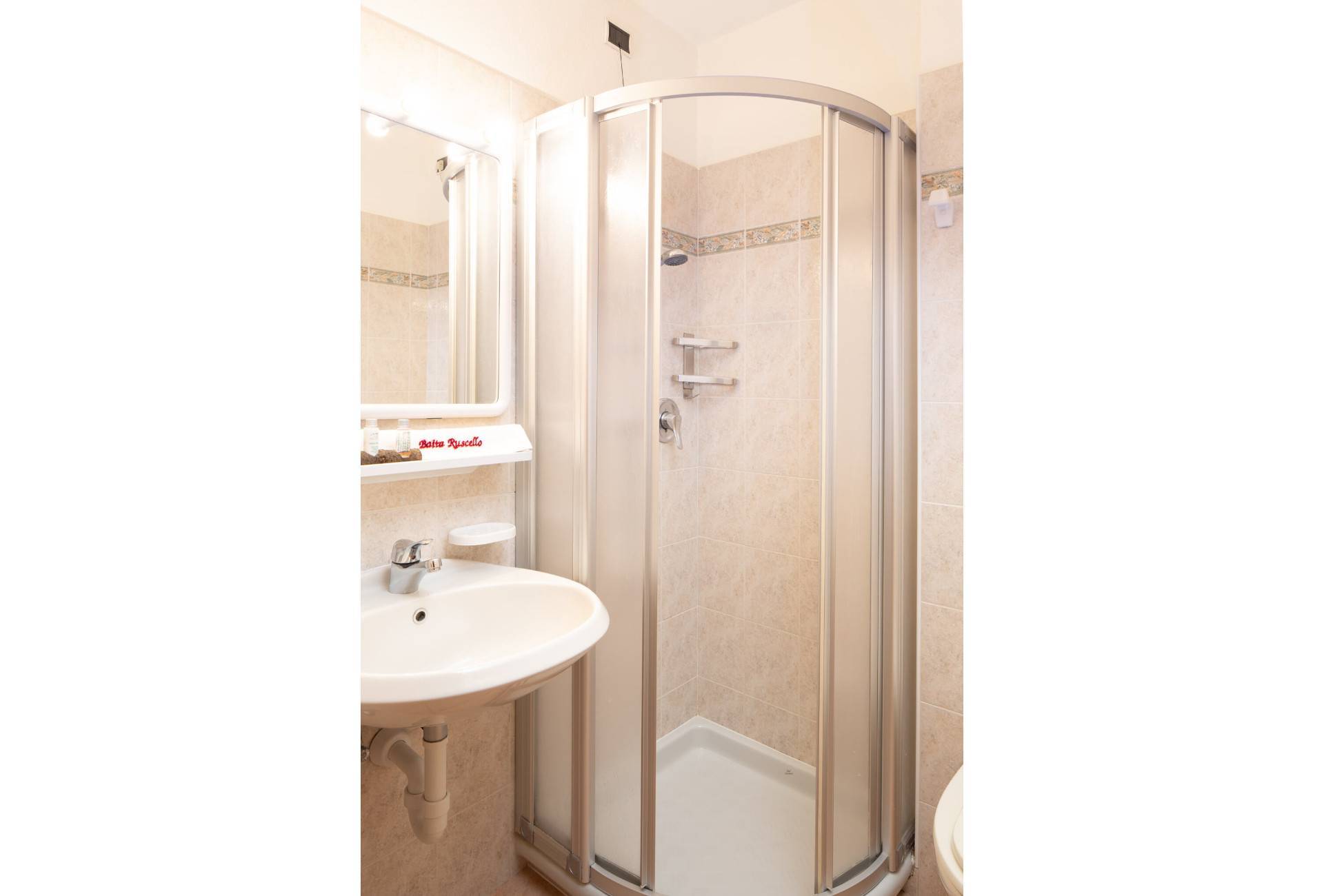 A bathroom with tub and one with shower in the Rosa Apartment of Baita Ruscello